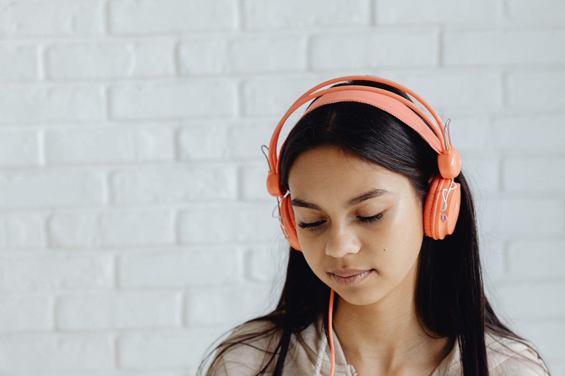 Estudante de fones com os olhos fechados, concentrada só no áudio