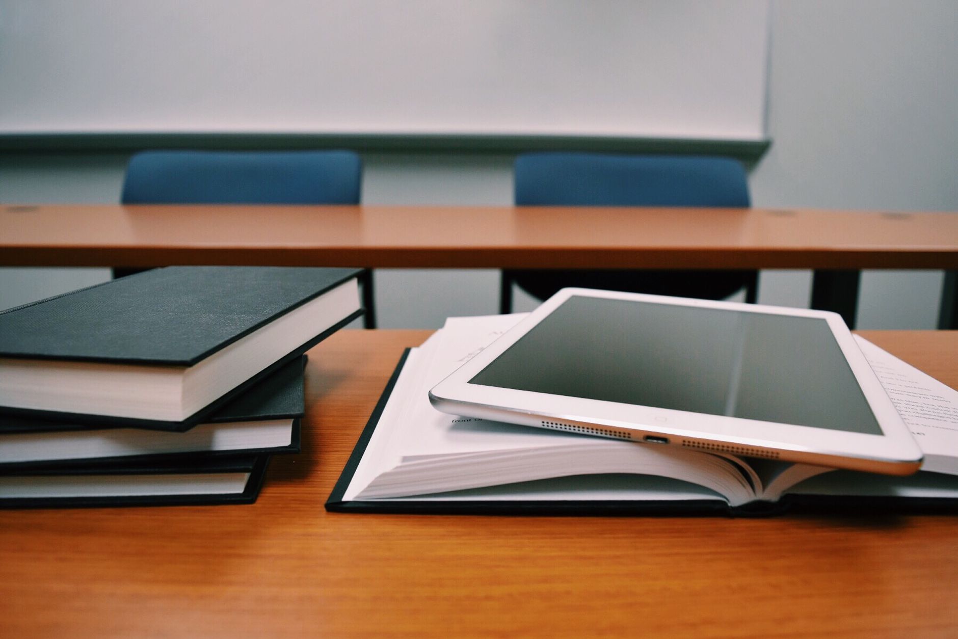 Tablet sobre um livro aberto em uma sala de aula