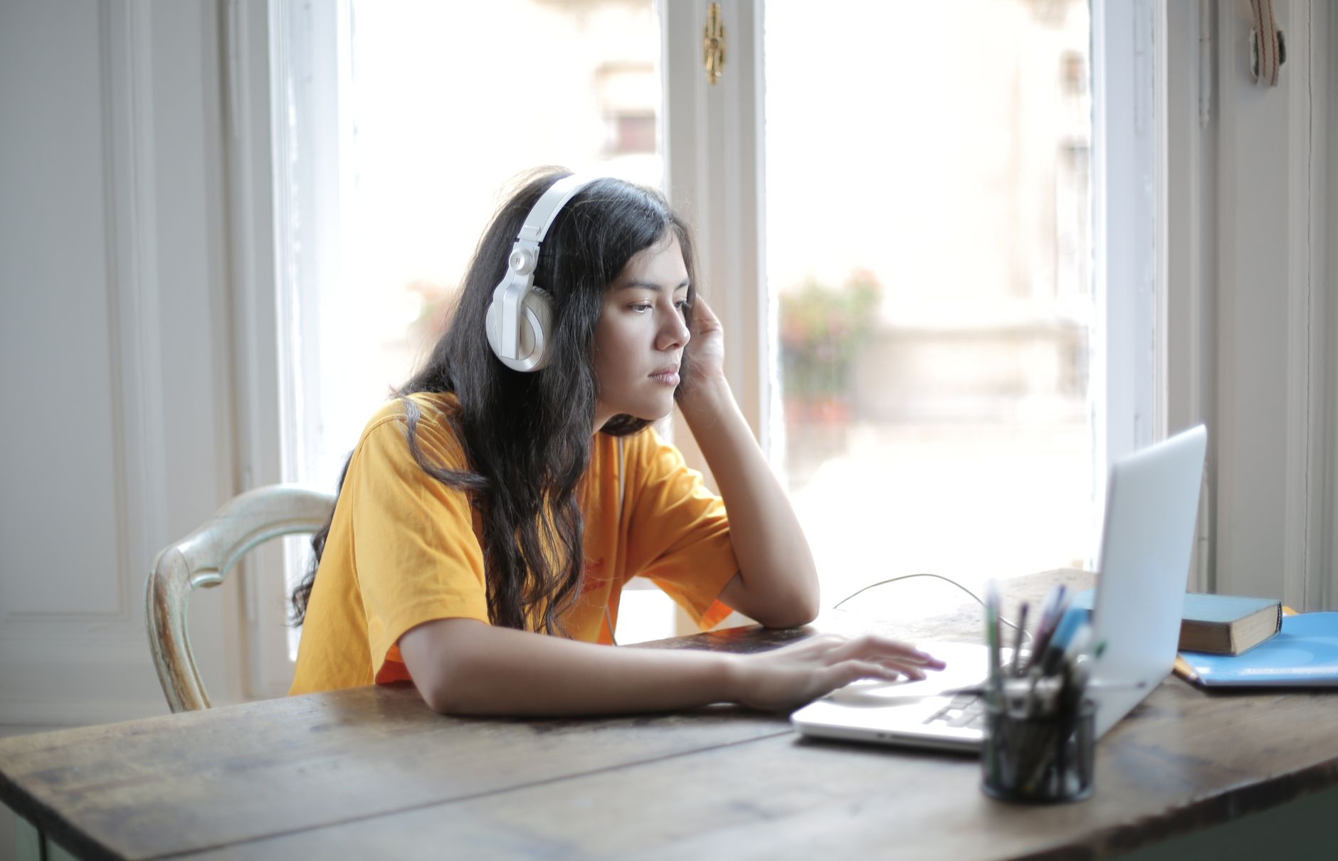 Estudante de inglês com fones de ouvido treinando a escuta no laptop