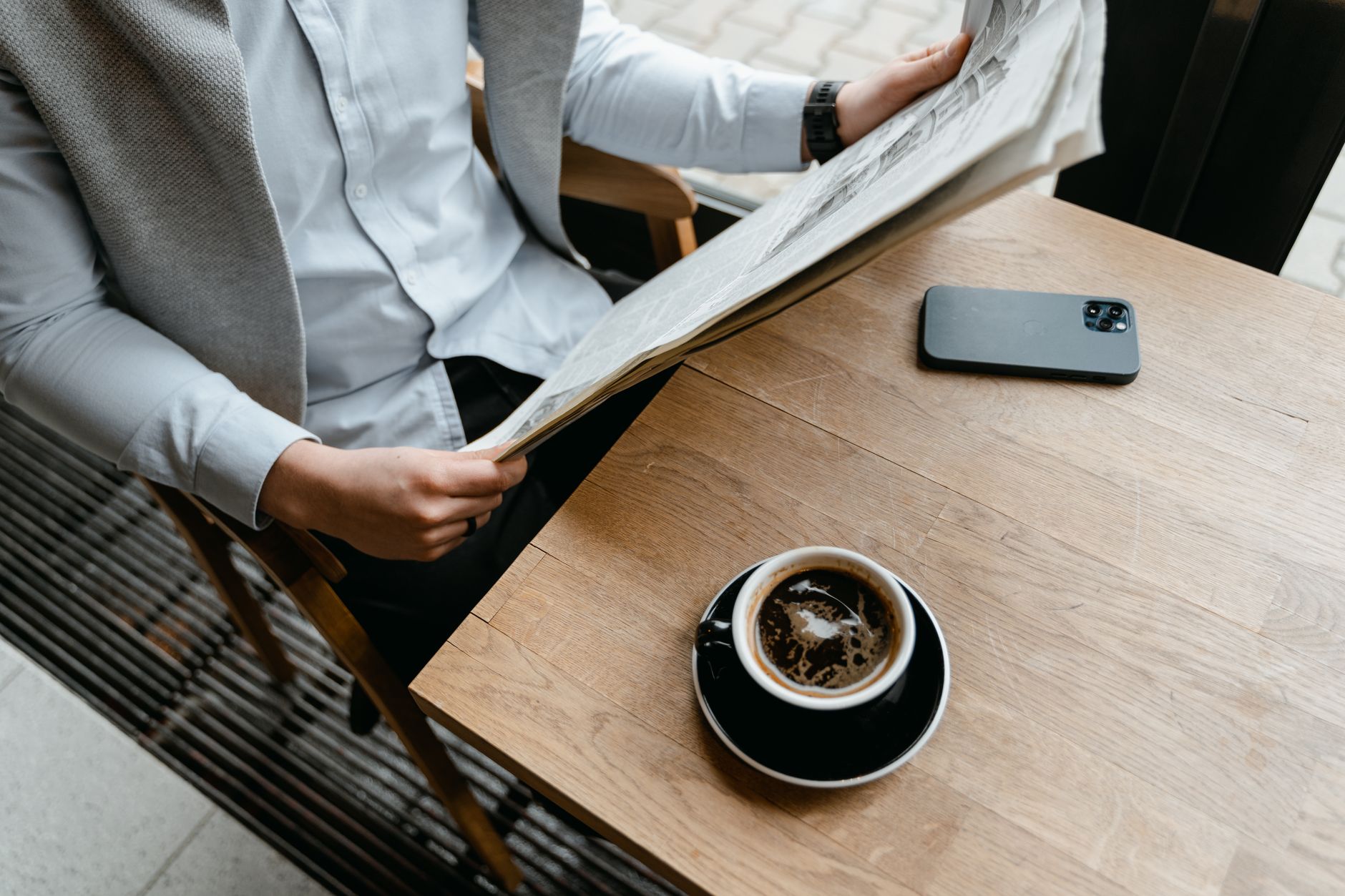 Pessoa lendo notícia com café — o hábito diário de leitura em inglês