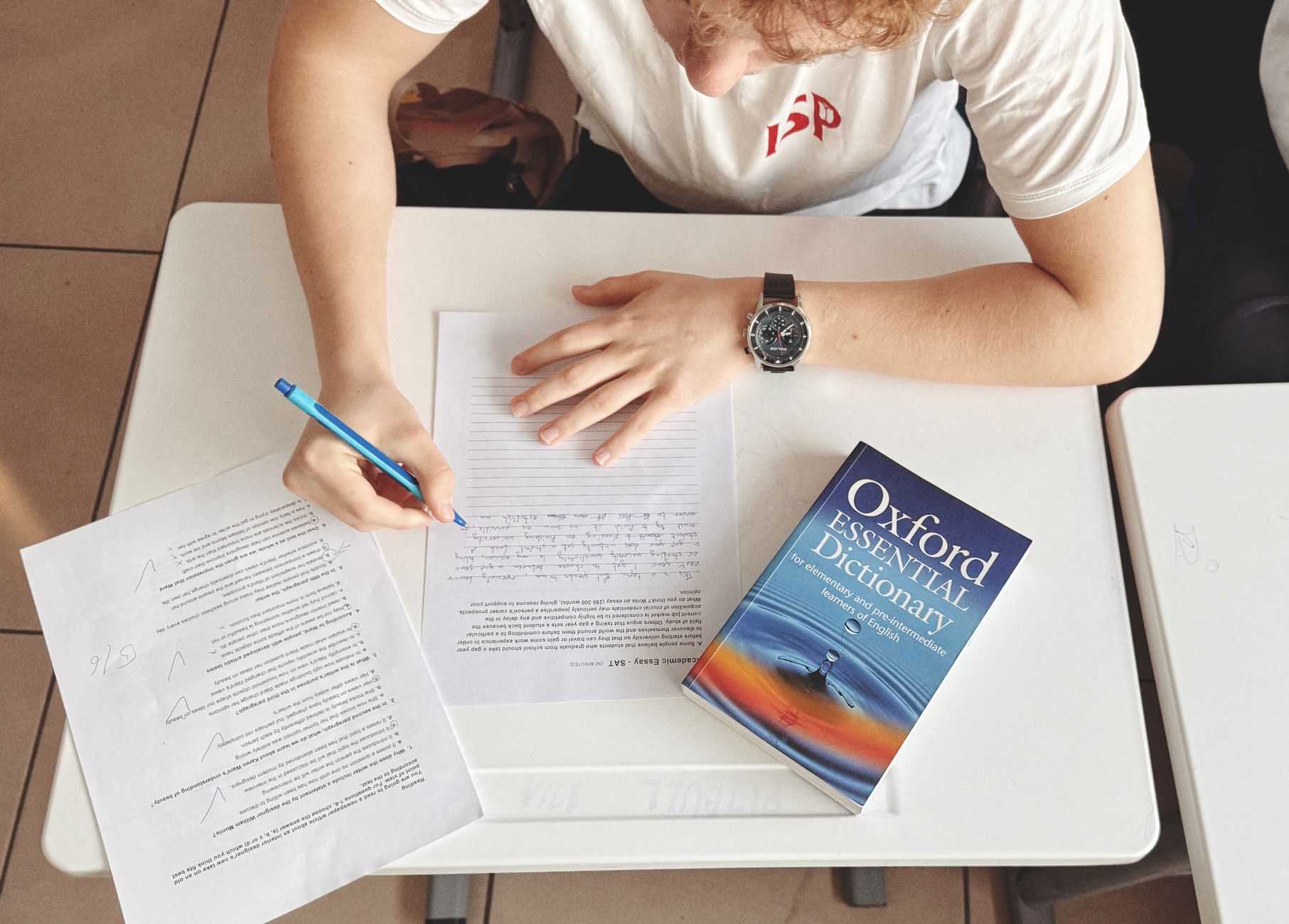 Estudante fazendo teste de inglês com dicionário Oxford sobre a mesa